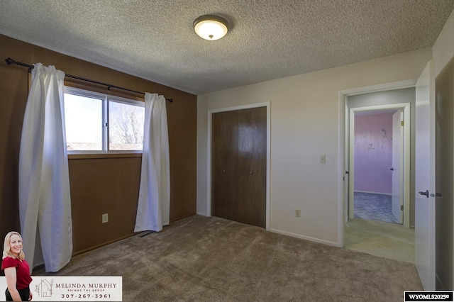 unfurnished bedroom featuring a textured ceiling, a closet, and carpet