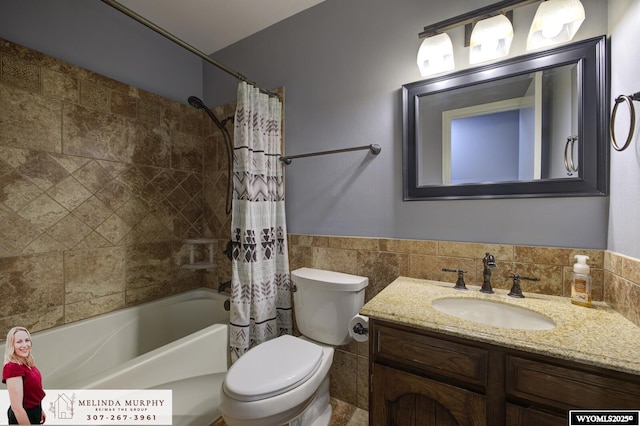 bathroom featuring toilet, shower / bath combo, vanity, and tile walls