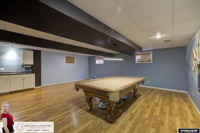 recreation room featuring a paneled ceiling, visible vents, a sink, light wood-type flooring, and baseboards