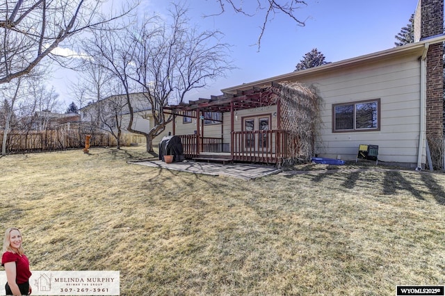 exterior space featuring fence, french doors, a lawn, and a wooden deck