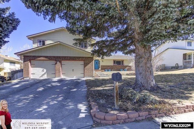 view of front of house with driveway, a garage, and brick siding