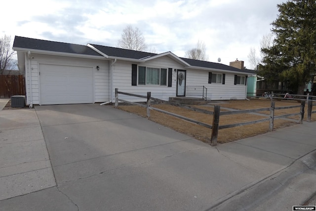 ranch-style house featuring an attached garage, driveway, a fenced front yard, and a chimney