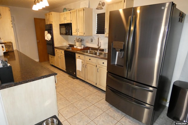 kitchen featuring light tile patterned floors, dark countertops, light brown cabinets, a sink, and black appliances