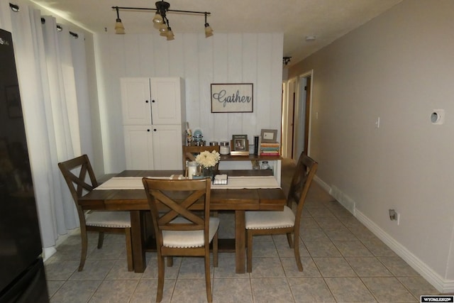 dining room featuring light tile patterned flooring and baseboards