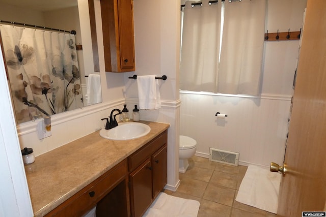 bathroom featuring toilet, vanity, tile patterned flooring, and visible vents