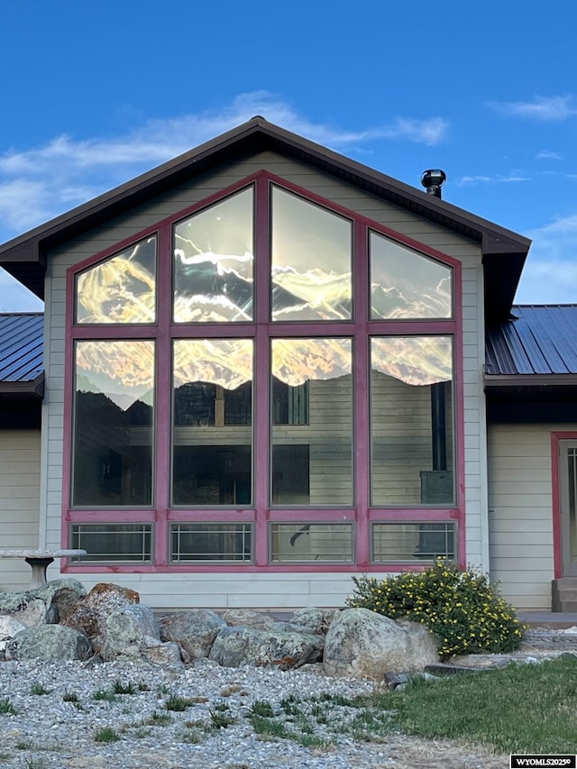 view of home's exterior with a sunroom and metal roof