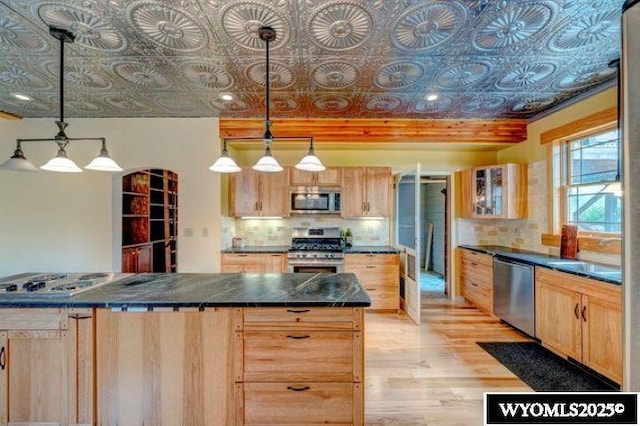 kitchen featuring stainless steel appliances, light brown cabinets, and an ornate ceiling