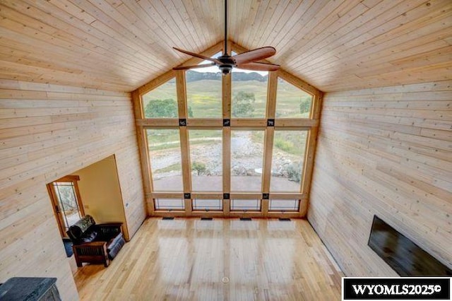 unfurnished living room featuring a wealth of natural light, wood ceiling, and wood finished floors