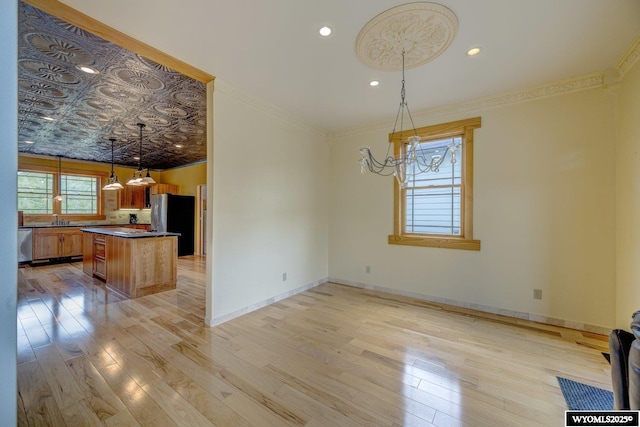 kitchen with stainless steel appliances, dark countertops, a sink, and a wealth of natural light