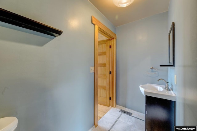 half bathroom featuring toilet, baseboards, visible vents, and vanity