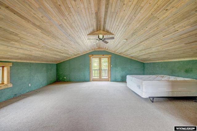 unfurnished bedroom with wooden ceiling, ceiling fan, access to exterior, carpet, and vaulted ceiling