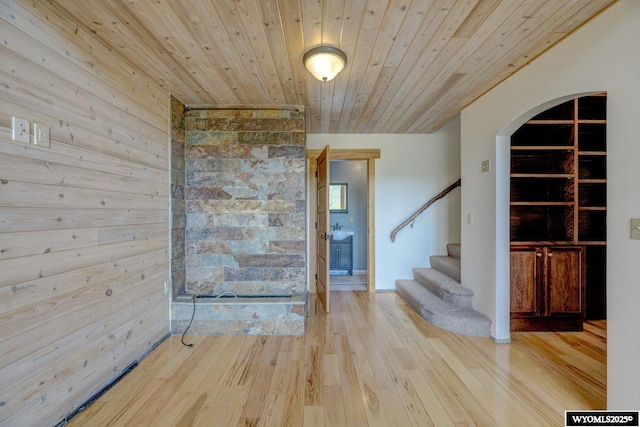 interior space with wooden ceiling, stairway, arched walkways, and wood finished floors