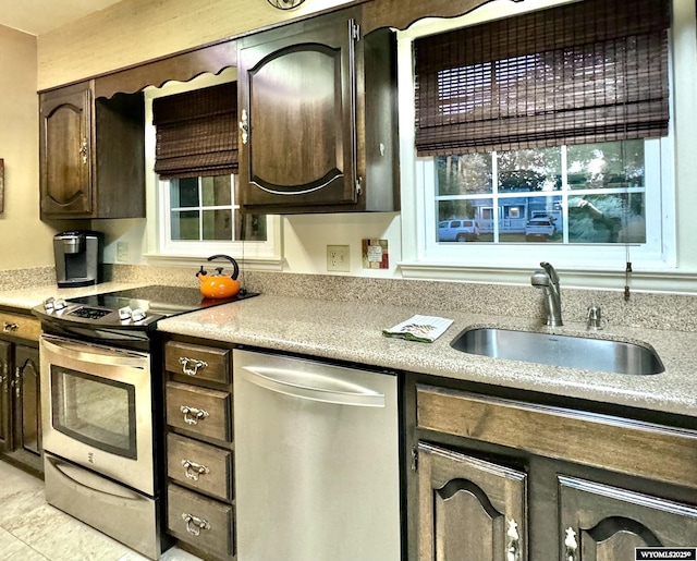 kitchen featuring dark brown cabinets, appliances with stainless steel finishes, a sink, and light countertops