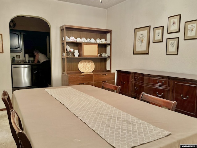 bedroom featuring arched walkways and a textured ceiling