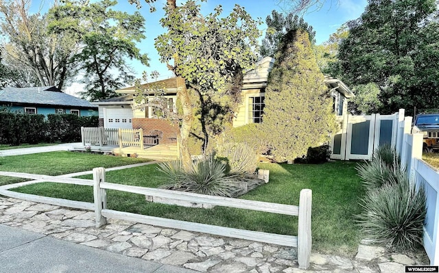 exterior space with an attached garage, fence, and a lawn