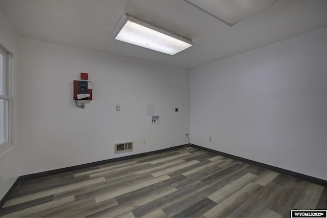 unfurnished room with dark wood-type flooring, a healthy amount of sunlight, visible vents, and baseboards