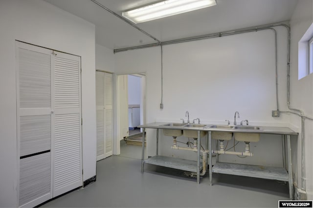 kitchen featuring a sink and finished concrete flooring