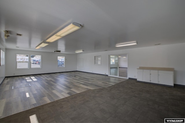 empty room featuring baseboards, visible vents, and wood finished floors