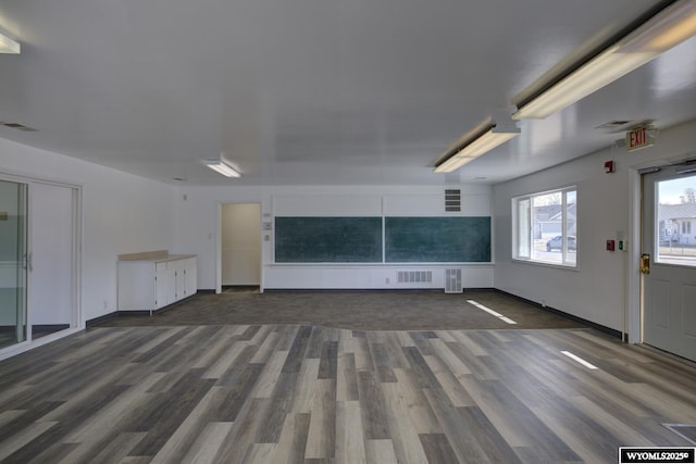 unfurnished living room featuring wood finished floors and visible vents