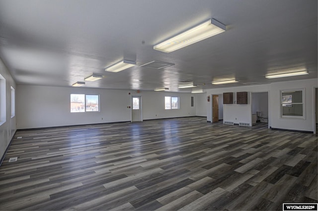 unfurnished room featuring dark wood-style floors, attic access, and visible vents