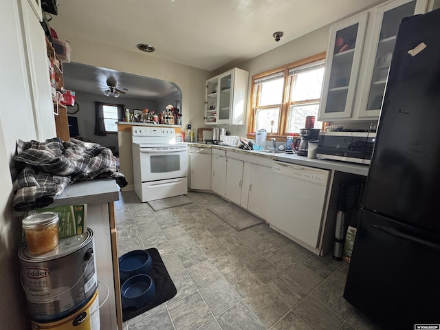 kitchen with white appliances, glass insert cabinets, a sink, and white cabinetry