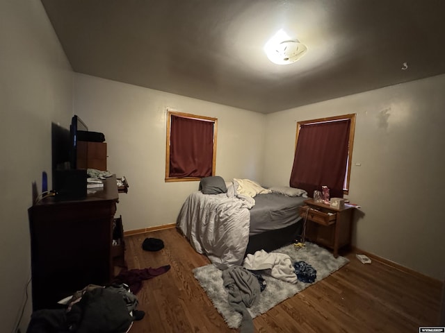 bedroom with baseboards and wood finished floors