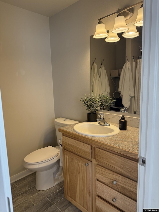 bathroom with wood finish floors, vanity, and toilet