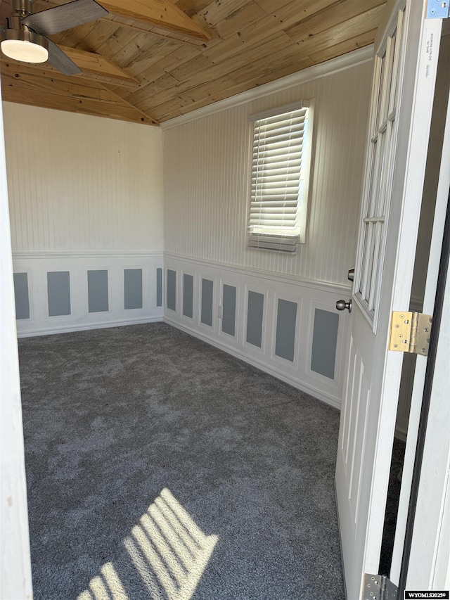 carpeted spare room featuring wooden ceiling