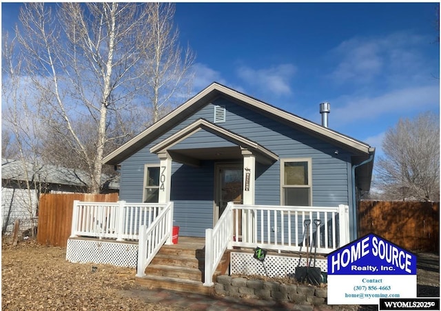 view of front of home with covered porch and fence