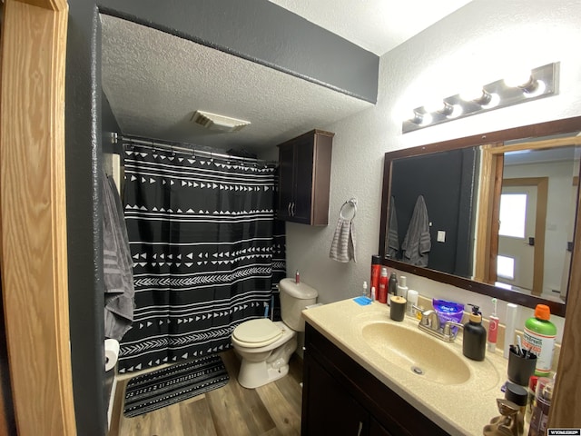 full bathroom featuring visible vents, a textured wall, toilet, wood finished floors, and a textured ceiling