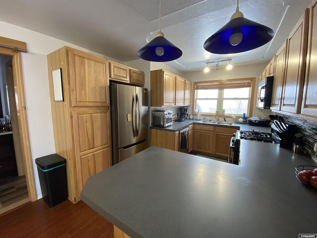 kitchen featuring a toaster, dark wood-type flooring, a peninsula, stainless steel appliances, and a textured ceiling