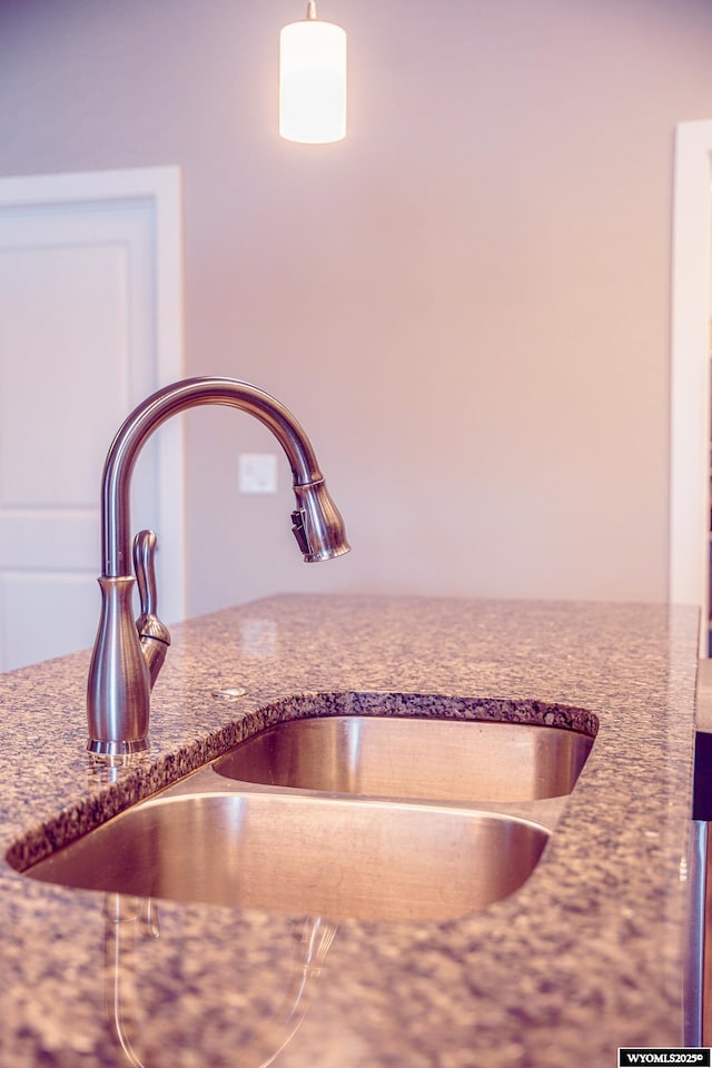 details with dark stone countertops and a sink