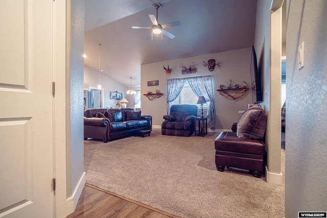 carpeted living area featuring ceiling fan, vaulted ceiling, wood finished floors, and a textured wall