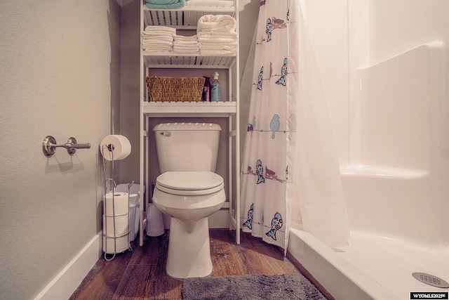 bathroom featuring toilet, baseboards, and wood finished floors