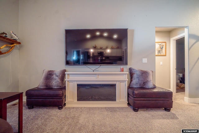 living room with carpet floors and a glass covered fireplace