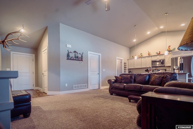 carpeted living area with high vaulted ceiling, baseboards, visible vents, and ceiling fan