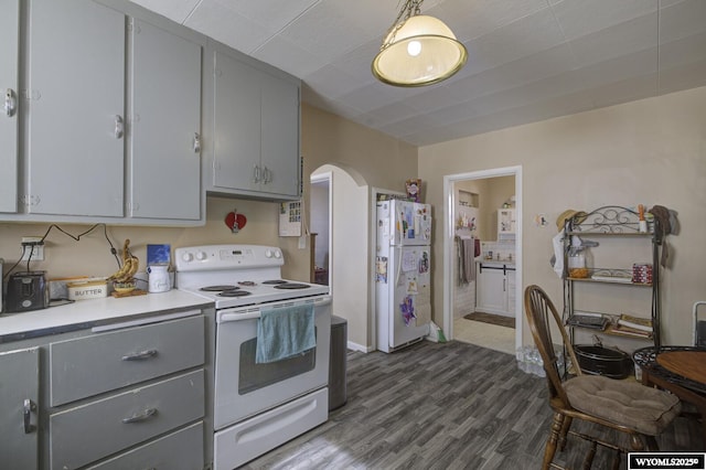 kitchen with gray cabinets, arched walkways, white appliances, and dark wood-type flooring