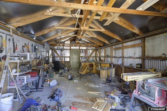 misc room with a garage, vaulted ceiling, and a workshop area