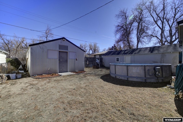 exterior space with an outbuilding, an outdoor pool, and fence