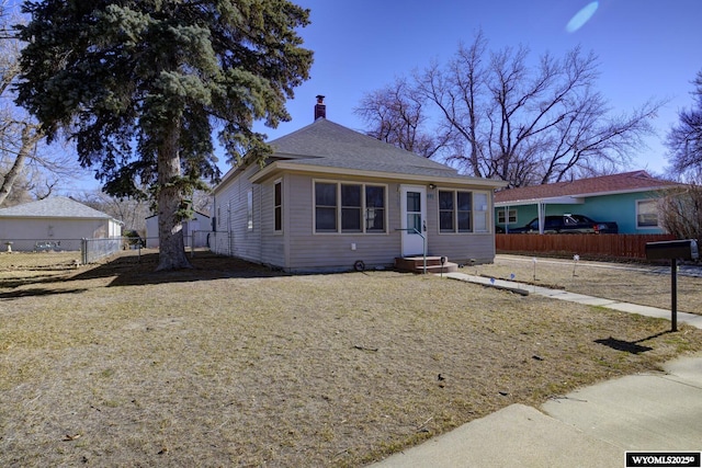 bungalow with entry steps, fence, and a chimney