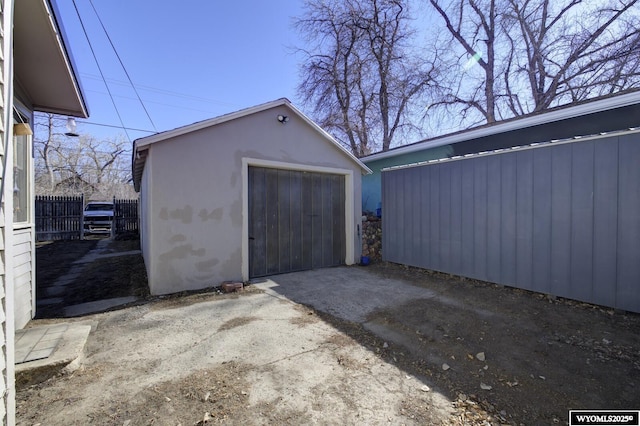 detached garage with driveway and fence