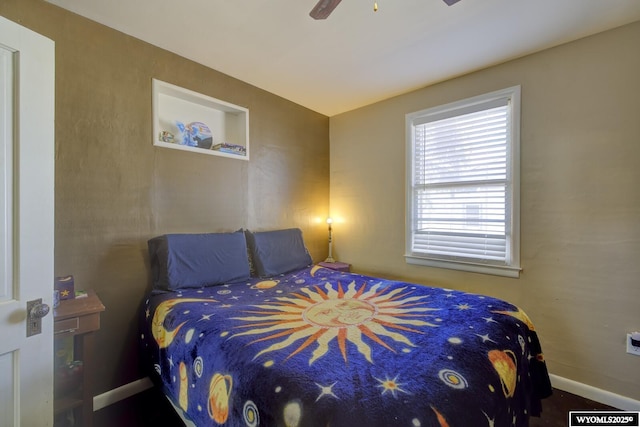 bedroom with a ceiling fan and baseboards