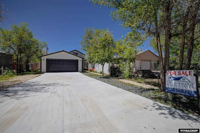 view of front of house with a garage, fence, and driveway