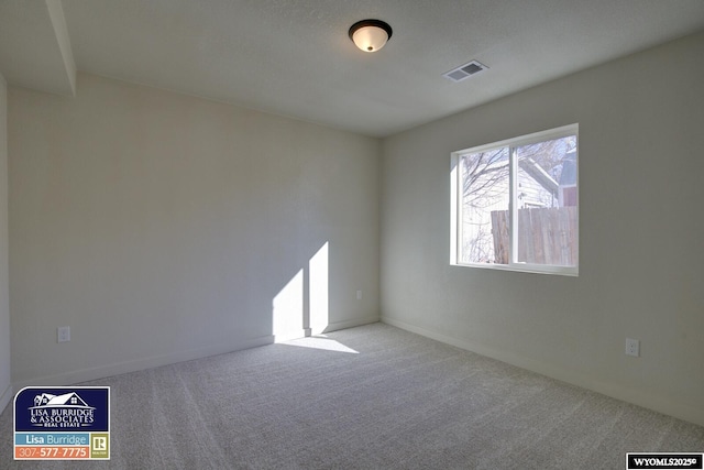 carpeted spare room with baseboards and visible vents