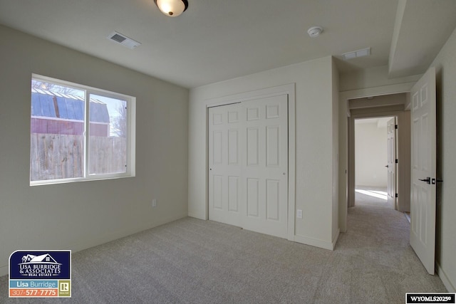 unfurnished bedroom featuring carpet, visible vents, and a closet