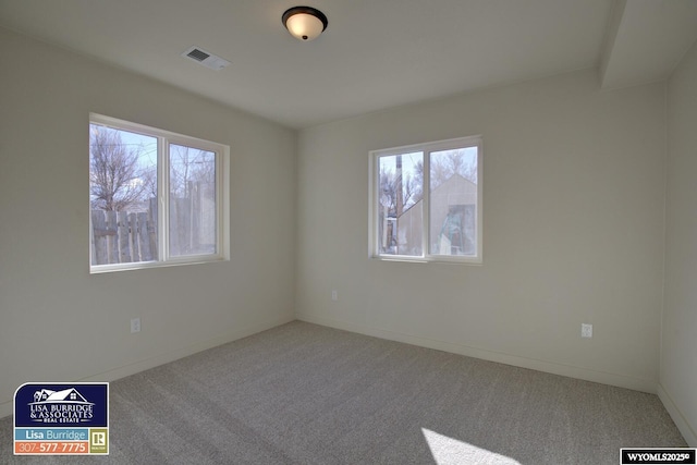 unfurnished room featuring carpet, visible vents, and a healthy amount of sunlight