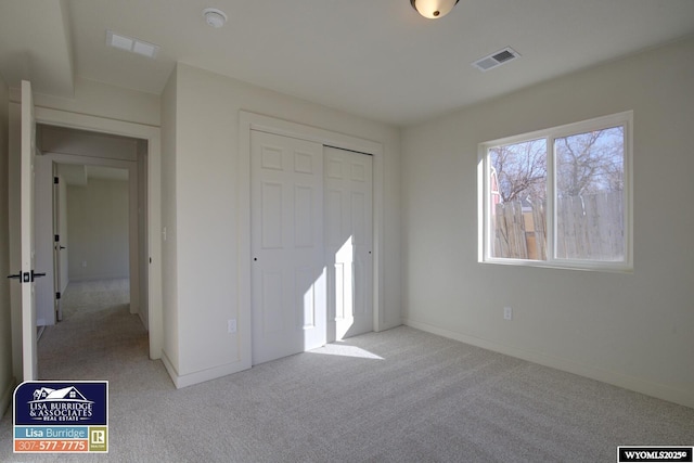 unfurnished bedroom with carpet, a closet, visible vents, and baseboards