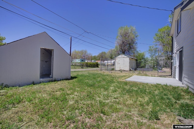 view of yard featuring an outbuilding, a storage unit, and fence