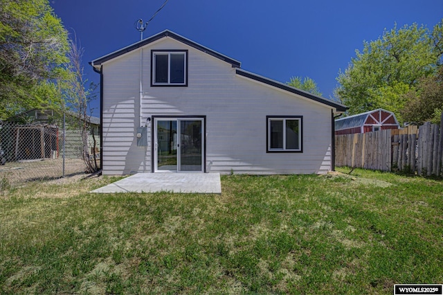 rear view of property with a patio, a lawn, and a fenced backyard