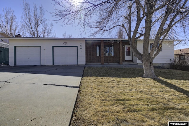 ranch-style home featuring an attached garage, a front lawn, concrete driveway, and brick siding